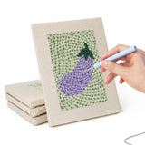 Hand punching one of the Carrot and Eggplant mini canvases
