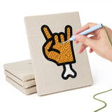 Hand punching one of the Cat and Bat mini canvases