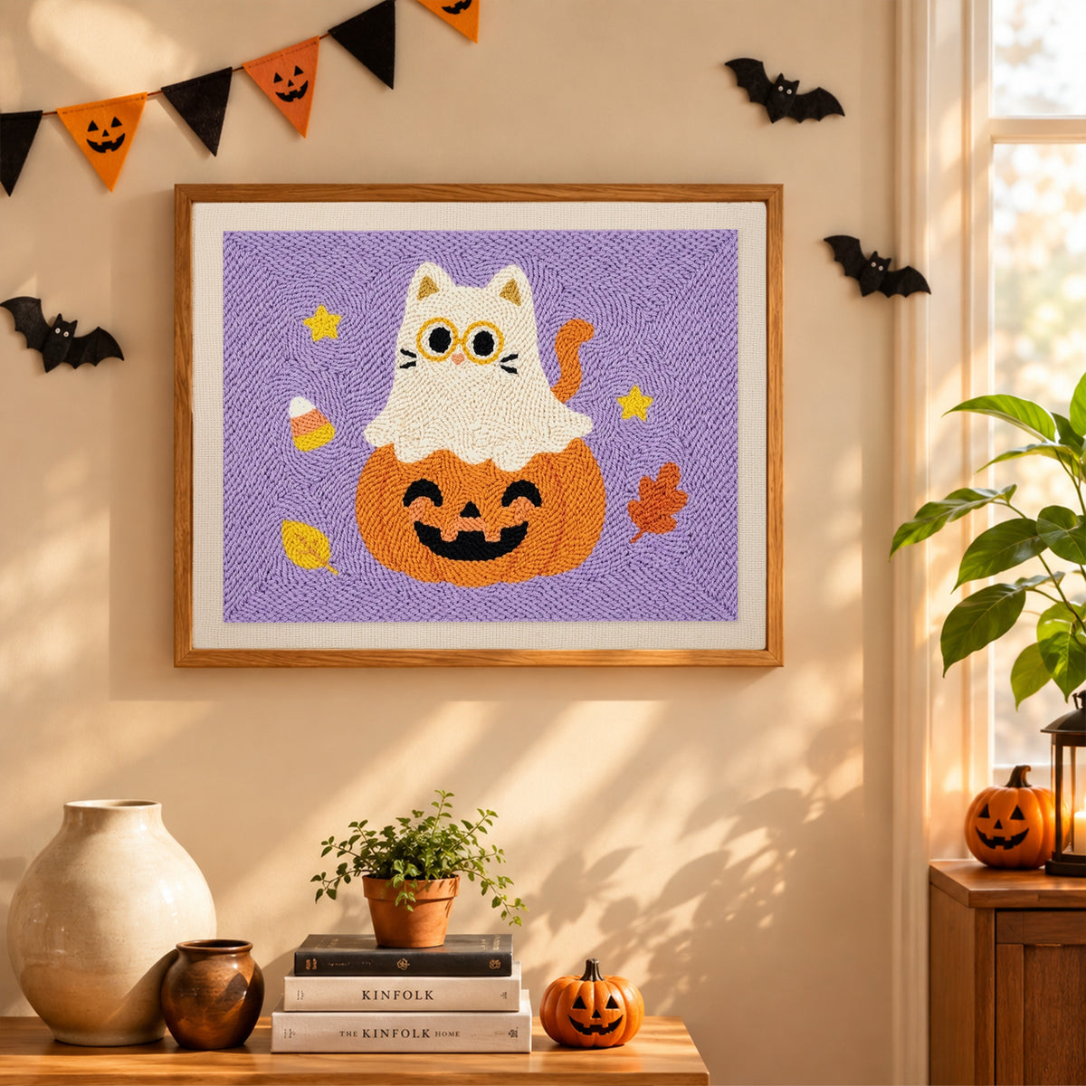 Finished Cat Ghost on a Pumpkin punch needle canvas on a wall