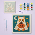 Cat in a Ghost Sheet canvas before and after punching, with the threads and tools