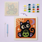 Cat with Skull Pail canvas before and after punching, with the threads and tools