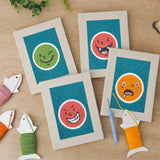 The four finished Cheeky Face Circles mini canvases laid out on a table