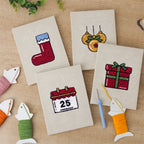 The four finished Christmas Morning mini canvases laid out on a table