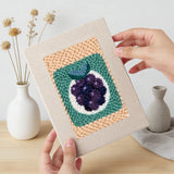 Hand holding a finished Citrus and Blackberries mini canvas