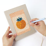 Punching a Citrus and Blackberries mini canvas with the punch needle
