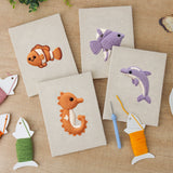 The four finished Clownfish Reef mini canvases laid out on a table