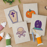 The four finished Coffin and Gravestone mini canvases laid out on a table