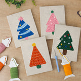 The four finished Colorful Christmas Trees mini canvases laid out on a table