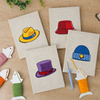 The four finished Colorful Hats mini canvases laid out on a table