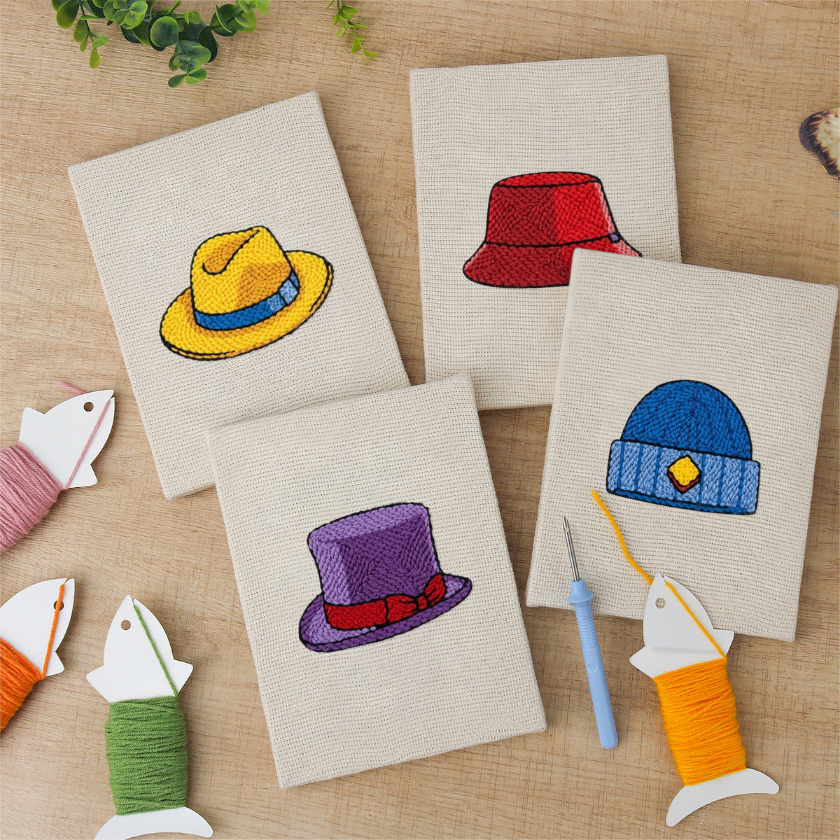 The four finished Colorful Hats mini canvases laid out on a table