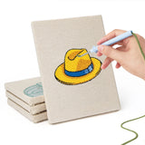 Hand punching one of the Colorful Hats mini canvases