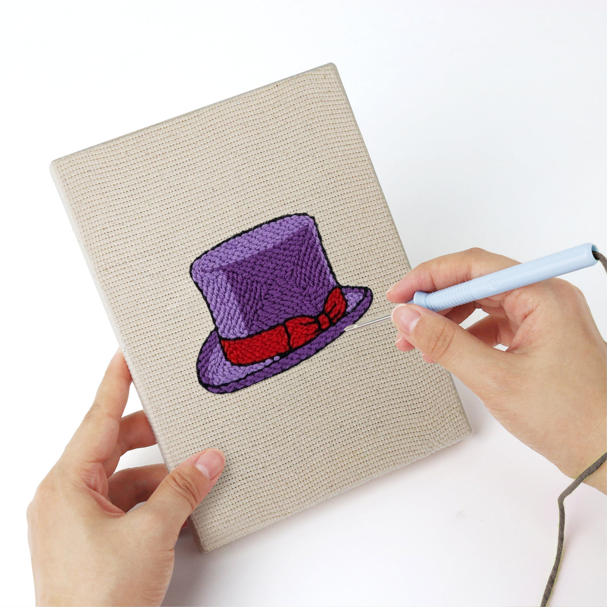 Punching a Colorful Hats mini canvas with the punch needle