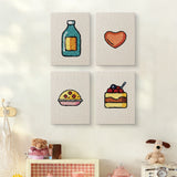 The four Cookie and Cake mini canvases on a wall above a shelf