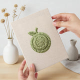 Hand holding a finished Corn and Cabbage mini canvas