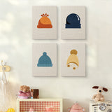 The four Cozy Beanies mini canvases on a wall above a shelf