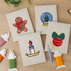 The four finished Cozy Christmas mini canvases laid out on a table