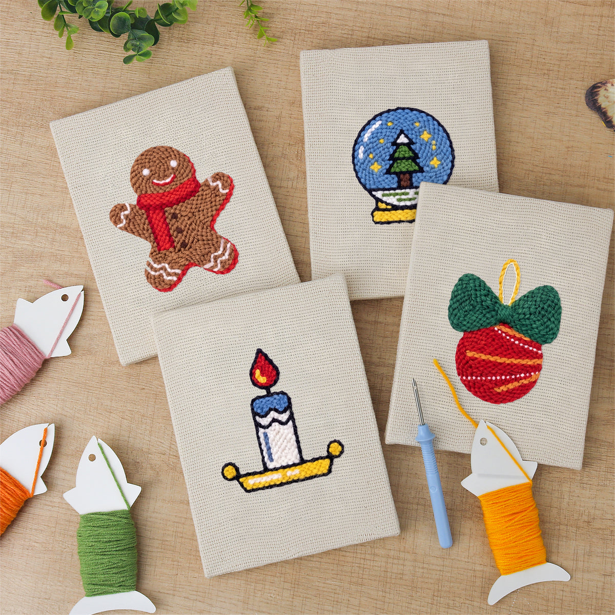The four finished Cozy Christmas mini canvases laid out on a table