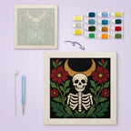 Crescent Moon Skeleton canvas before and after punching, with the threads and tools