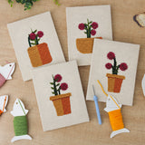 The four finished Crimson Bloom Pots mini canvases laid out on a table