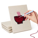 Hand punching one of the Croissant Tea Break mini canvases