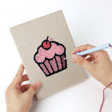 Punching a Croissant Tea Break mini canvas with the punch needle