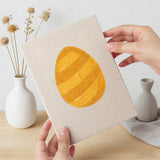 Hand holding a finished Daisy Star Eggs mini canvas