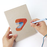 Punching a Desk Essentials mini canvas with the punch needle