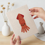 Hand holding a finished Dolphin and Squid mini canvas