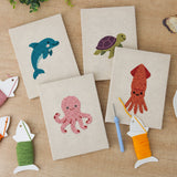 The four finished Dolphin and Squid mini canvases laid out on a table