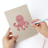 Punching a Dolphin and Squid mini canvas with the punch needle