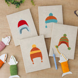 The four finished Earflap Winter Hats mini canvases laid out on a table