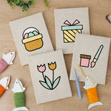 The four finished Egg Basket Spring mini canvases laid out on a table