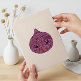 Hand holding a finished Fig and Cauliflower mini canvas