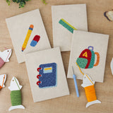 The four finished First Day Backpack mini canvases laid out on a table