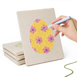 Hand punching one of the Floral Easter Eggs mini canvases