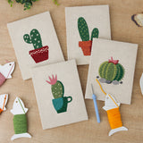The four finished Flowering Cacti mini canvases laid out on a table