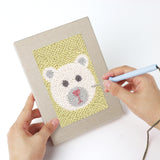 Punching a Fluffy Friends mini canvas with the punch needle
