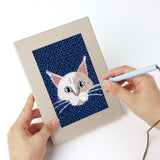 Punching a Fluffy Pet Portraits mini canvas with the punch needle