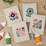 The four finished Folk Bunny Blooms mini canvases laid out on a table