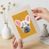 Hand holding a finished Frenchie and Bunny mini canvas