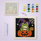 Frog Witch on a Pumpkin canvas before and after punching, with the threads and tools