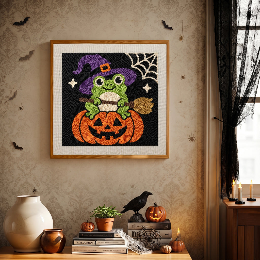 Finished Frog Witch on a Pumpkin punch needle canvas on a wall