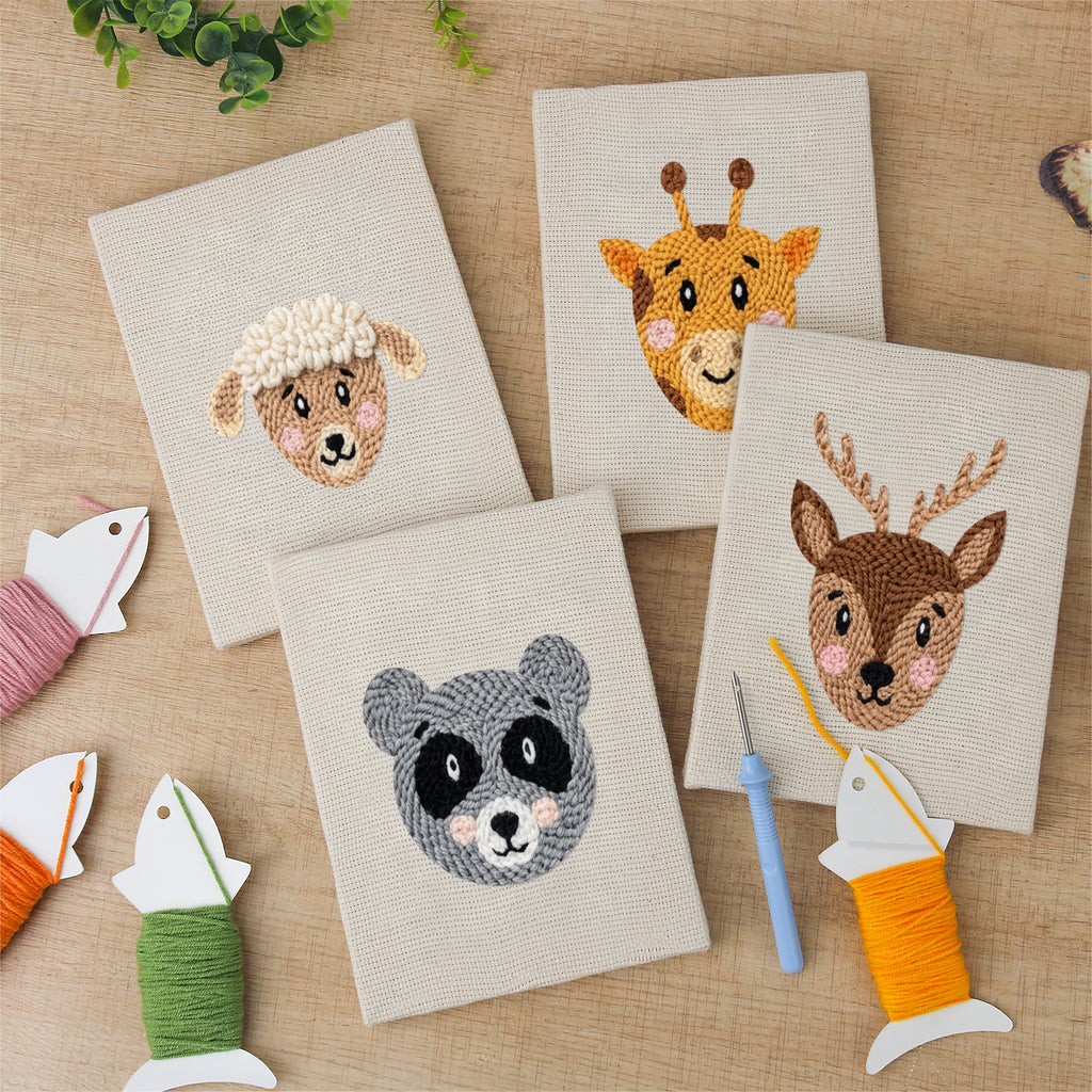 The four finished Giraffe and Deer mini canvases laid out on a table