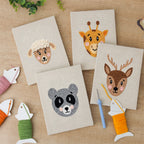 The four finished Giraffe and Deer mini canvases laid out on a table