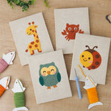 The four finished Giraffe and Friends mini canvases laid out on a table