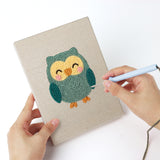 Punching a Giraffe and Friends mini canvas with the punch needle