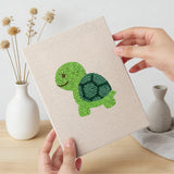Hand holding a finished Giraffe and Turtle mini canvas