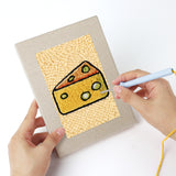 Punching a Golden Snack Time mini canvas with the punch needle