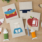 The four finished Graduation Satchel mini canvases laid out on a table