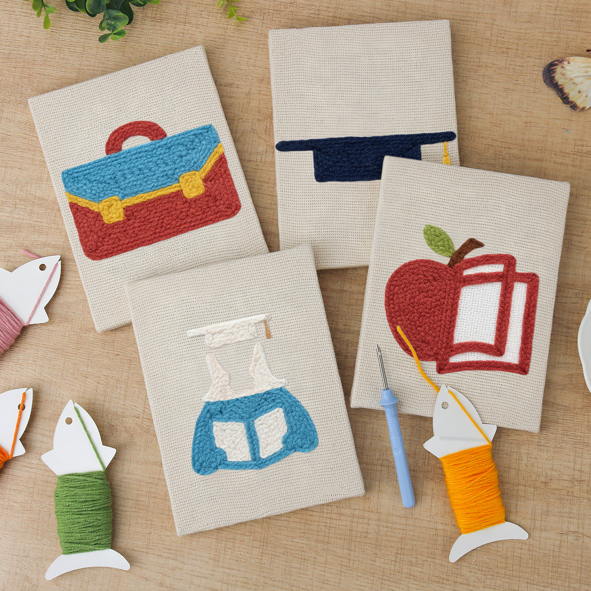 The four finished Graduation Satchel mini canvases laid out on a table